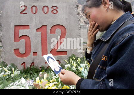 --FILE--Une femme chinoise pleure sur l'un des membres de sa famille qui sont morts dans le séisme du 12 mai en face d'une pierre tombale, lors d'un mémorial en public Être Banque D'Images