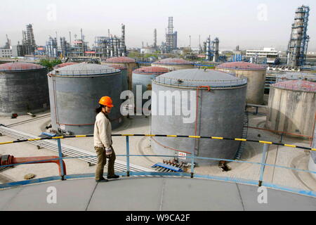 --FILE--un travailleur d'usine chinoise est vu sur un réservoir de stockage d'huile dans une raffinerie de PetroChina Lanzhou Petrochemical Company, une filiale de la CNPC (Chine Banque D'Images