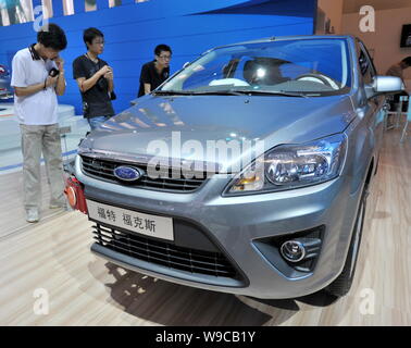 --FILE--visiteurs chinois regarder une Ford Focus, fabriqué par ChangAn Ford, la coentreprise entre Ford et ChangAn Automobile Co., Ltd., au cours d'une Banque D'Images