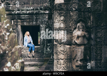 Young blonde woman découvrir les ruines du temple d'Angkor Wat à Siem Reap, Cambodge. Banque D'Images