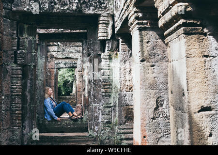 Young blonde woman découvrir les ruines du temple d'Angkor Wat à Siem Reap, Cambodge. Banque D'Images