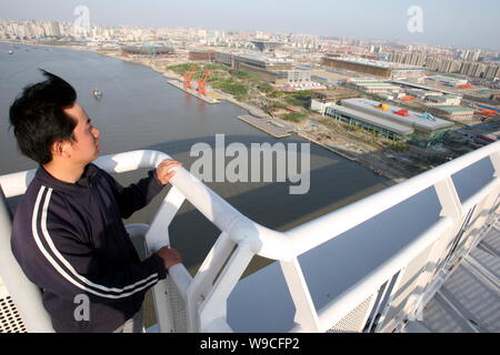 Un visiteur chinois observe l'Exposition Universelle 2010 de Shanghai sur site haut de Lupu Pont sur la rivière Huangpu à Shanghai, Chine, le mercredi, 29 avril 2009. Banque D'Images