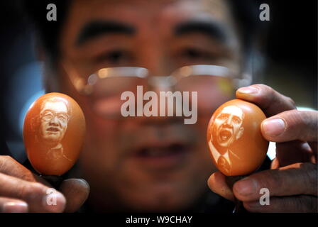 Sculpteur folk chinois Kang Yongguo montre deux œufs sculptés avec les portraits du président chinois Hu Jintao, à gauche, et le président américain Barack Obama à l'heure h Banque D'Images