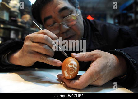 Sculpteur folk chinois Kang Yongguo sculpte le portrait du président américain Barack Obama sur la coquille d'un oeuf de poule dans son atelier à Shenyang city, pas de Banque D'Images