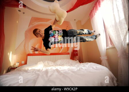 Un jeune homme chinois saute sur un lit dans un hôtel de Shanghai, Chine de l'est la province de Shandong, 26 décembre 2009. Double saut est chaud maintenant amomg les jeunes Chinois Banque D'Images