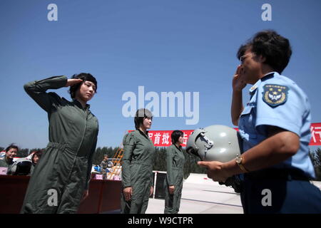 Un vétéran femme pilote, droite, et d'une jeune femme pilote d'avion de chasse pour saluer l'autre lors d'une nouvelle cérémonie de livraison des combinaisons de vol dans un aéroport i Banque D'Images