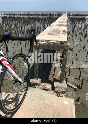 Le vélo à la fin de la voie par la mer. Broken Road sur la côte avec une protection contre l'érosion des terres, la Thaïlande. Banque D'Images