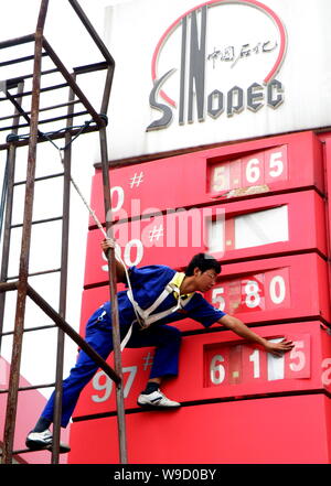 --FILE--Un travailleur chinois station-service mises des prix de l'essence à une station-service de Sinopec à Yichang city, province de Hubei, Chine centrale 29 juillet 2009. Banque D'Images