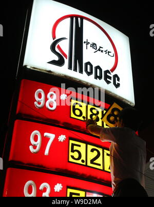 Un travailleur chinois station-service mises des prix de l'essence à une station-service de Sinopec à Beijing, Chine, lundi 1er juin 2009. La Chine a augmenté les prix du carburant Banque D'Images