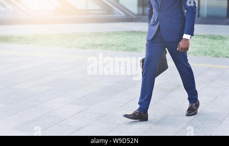 L'homme d'affaires afro avec marche porte-documents en zone urbaine, culture, Copyspace Banque D'Images