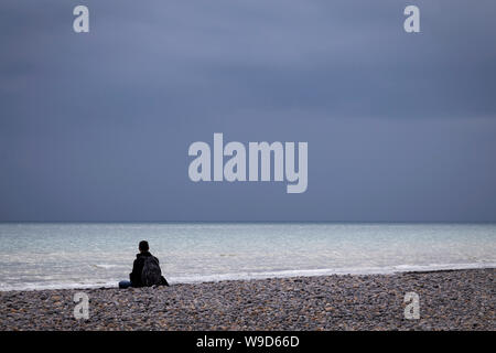 Homme assis dans la contemplation at beach Banque D'Images