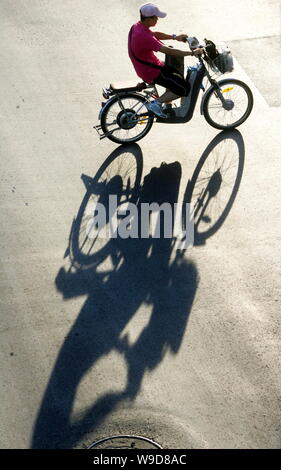 --FILE--un Chinois chevauche son vélo électrique dans une rue de Shanghai, Chine, le 6 août 2008. En Chine, les vélos électriques quittent voitures dans le Banque D'Images