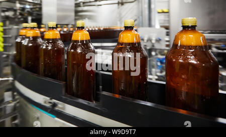 Les nouvelles bouteilles en plastique sur le convoyeur à bande à l'usine de bière potable. L'eau potable processus de fabrication. Shallow DOF. Focus sélectif. Banque D'Images