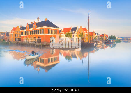 Maisons hollandaises traditionnelles avec un canal et bateaux sur un matin de printemps brumeux avec un ciel bleu et des couleurs vives - Pays-Bas - le droit de Voyage Banque D'Images
