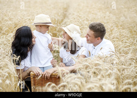 Happy Family - frères, soeur et maman s'amuser dans le champ de blé. Banque D'Images