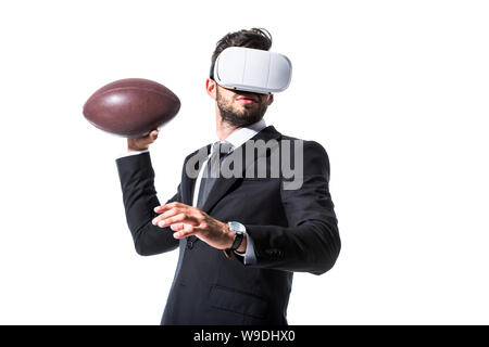 En homme d'usure formelle et casque de réalité virtuelle avec ballon de rugby Isolated On White Banque D'Images