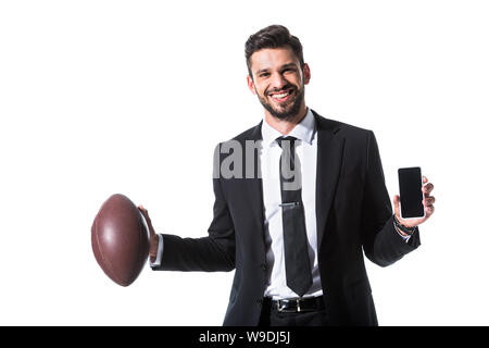 Portrait en tenue de cérémonie avec ballon de rugby et smartphone Isolated On White Banque D'Images