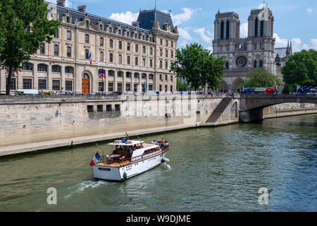 Bateau de tourisme sur la Seine passant Préfecture de Police sur la gauche avec la Cathédrale Notre-Dame à la distance, l'île de la Cité, Paris, France Banque D'Images