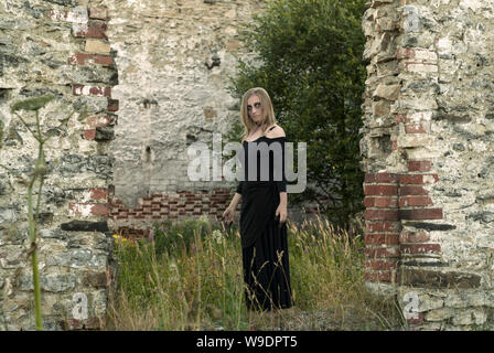 Fille dans l'image d'une sorcière au milieu des ruines antiques Banque D'Images