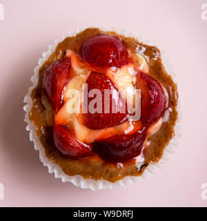 Tarte au fromage blanc crème aux fraises sur une plaque rose, vue de dessus. Mise à plat, vue d'en haut, d'en haut. Close-up. Banque D'Images