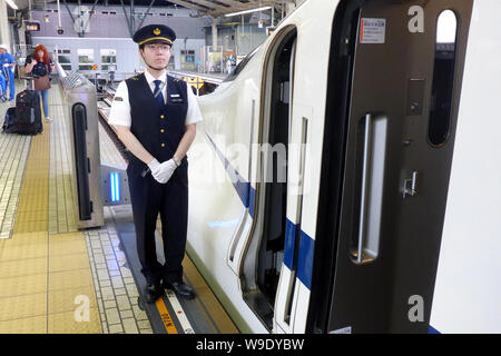 Tokyo, Japon. 18 mai, 2018. Un accompagnateur de train est debout à côté d'un train Shinkansen Express à la gare de Tokyo à l'embarquement d'un système de sécurité qui sépare le train de la voie et donc fixe. Tombe dans le lit de la voie ne sont pas possible de cette façon. Il existe des systèmes similaires dans environ 50 autres villes à travers le monde, dont certaines ont été en opération depuis les années 1990 - par exemple à Moscou, Londres et Barcelone. Crédit : Peter Gercke/dpa-Zentralbild/ZB/dpa/Alamy Live News Banque D'Images