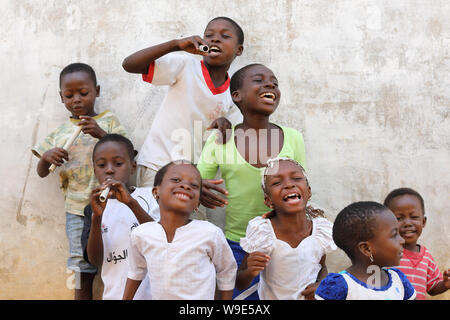 Les jeunes chanteurs heureux pratique une danse traditionnelle dans les rues d'Accra, Ghana Banque D'Images