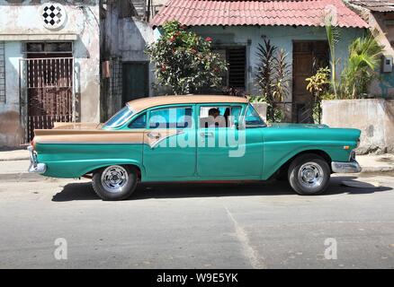 SANTIAGO, CUBA - février 10, 2011 : le pilote attend dans classic American 'Copier' voiture à Santiago de Cuba. Cuba a l'un des taux de location par habitant ra Banque D'Images