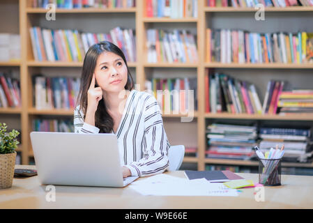 Jeune entreprise travailleur indépendant travaillant sur ordinateur intelligent en pensant à des idées nouvelles à l'office d'espace de travail Co Banque D'Images