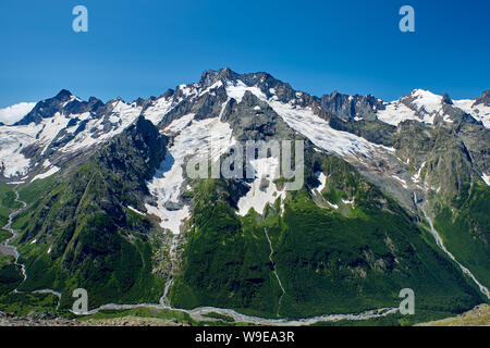 Des pics de montagne avec un glacier et le début d'un ruisseau de montagne. Nord du Caucase, Russie Banque D'Images