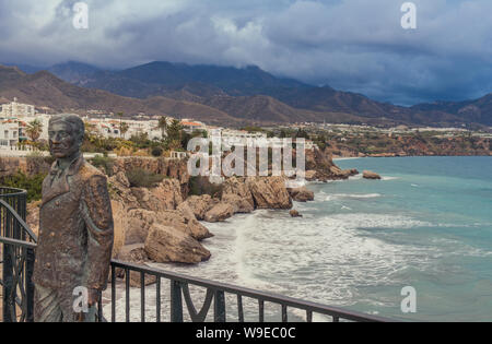 Nerja, Malaga, Espagne - 20 mars 2019 : Avis de tempête un coucher du soleil avec une statue de bronze dans un affût Banque D'Images