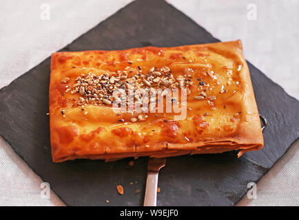 Fromage feta grecque traditionnelle appelée - enveloppé dans une croûte de pâte filo - avec du miel, sésame et noix Banque D'Images