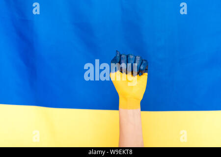 Portrait de la main peinte sur fond du drapeau de l'Ukraine Banque D'Images