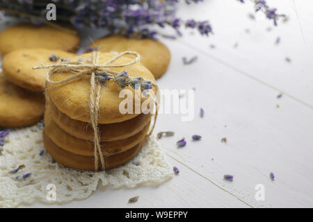 Les cookies à la lavande sur table en bois avec des fleurs de lavande séchées