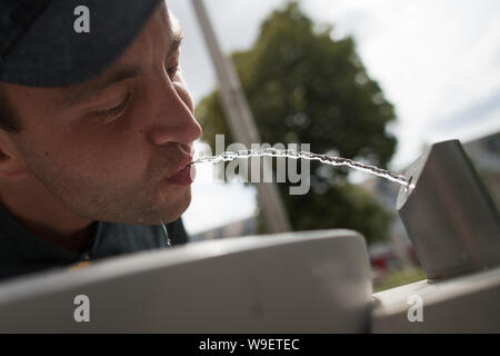 Berlin, Allemagne. Août 12, 2019. Patrick assouvit sa soif à un Berliner Wasserbetriebe bien. Credit : Jörg Carstensen/dpa/Alamy Live News Banque D'Images