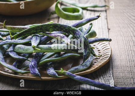 Les biologiques crus haricots crotale, légumes anciens dans une plaque en céramique, des aliments à base de plantes, Close up, selective focus Banque D'Images