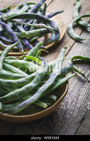 Les biologiques crus haricots crotale, légumes anciens dans une plaque en céramique, des aliments à base de plantes, Close up, selective focus Banque D'Images