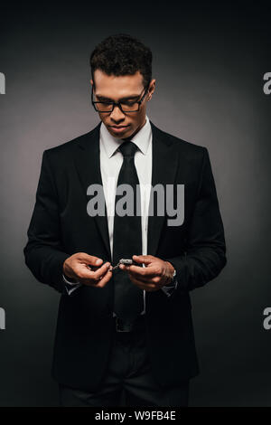 African American businessman holding car keys sur fond sombre Banque D'Images