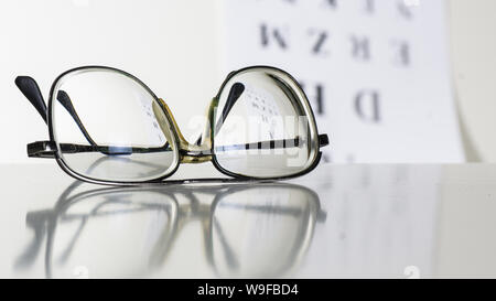 Vieux verres sur une table dans une pièce blanche. Banque D'Images