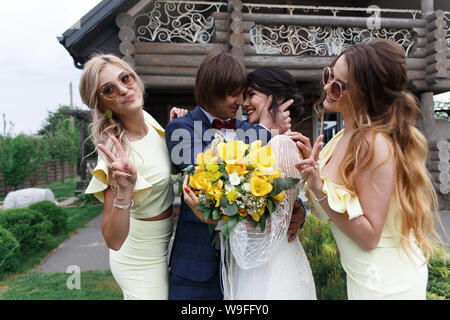 Les garçons et les demoiselles avec des nouveaux mariés lors de la cérémonie du mariage Banque D'Images