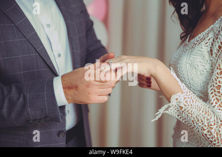 Met une bague sur la main de la Mariée . Groom met anneau de mariage sur la main de la mariée à l'église .homme met un anneau de mariage sur un côté de la mariée, close-up photo Banque D'Images