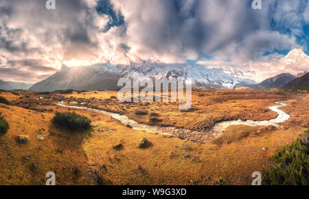 Paysage avec des montagnes aux sommets couverts de neige dans les nuages Banque D'Images