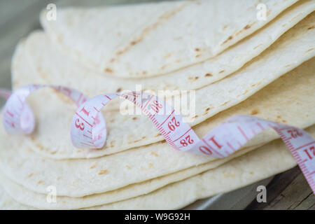 Close up of measuring tape sur le bas carb tortillas ou pain naan. Kéto friendly bas-carb - alimentaire plus sain - de près de l'image. Les tortillas sur la plaine Banque D'Images