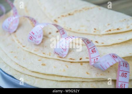 Close up of measuring tape sur le bas carb tortillas ou pain naan. Kéto friendly bas-carb - alimentaire plus sain - de près de l'image. Les tortillas sur la plaine Banque D'Images