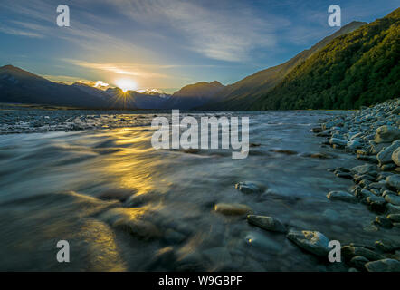 En regardant la rivière Waimakariri vers les montagnes d'Arthur's Pass, en Nouvelle-Zélande alors que le soleil se couche au printemps. Banque D'Images