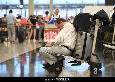 Hong Kong, Chine. Août 13, 2019. Les touristes sont bloqués en raison de chaos causé par les manifestants à l'Aéroport International de Hong Kong à Hong Kong, Chine du sud, le 13 août 2019. Les protestataires créé le chaos à l'Aéroport International de Hong Kong pour la deuxième journée de mardi, à l'origine de la plupart des annulations des vols à l'un des aéroports les plus achalandés au monde. Credit : Lui Siu Wai/Xinhua/Alamy Live News Banque D'Images