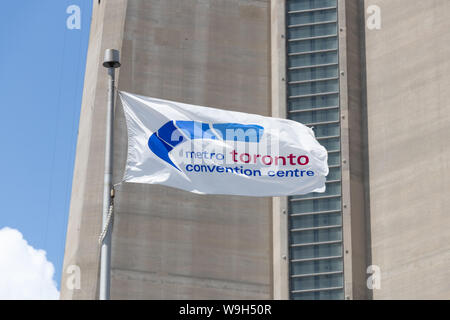 Metro Toronto Convention Centre drapeaux avec le CN Tower derrière. Banque D'Images