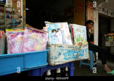 Un vendeur chinois vend des copies logicielles piratées de Microsoft Windows XP et des DVD de films de dessins animés piratés dans la rue de Shanghai 18 mai 2007. Banque D'Images
