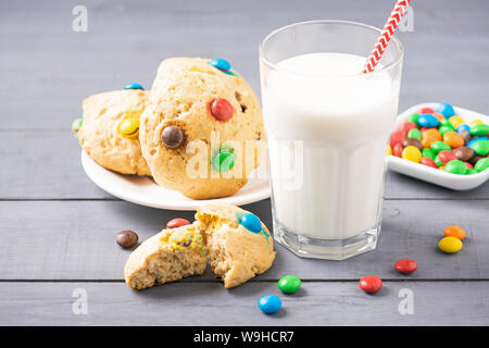 Un verre de lait et biscuits maison décorée de bonbons jelly beans. Le petit déjeuner des enfants snack. Banque D'Images