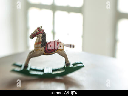 Cheval à bascule miniature en bois anciens balançoires sur une table Banque D'Images