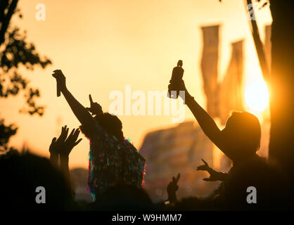 La danse au coucher du soleil au festival de Glastonbury 2019 dans Pilton, Somerset Banque D'Images